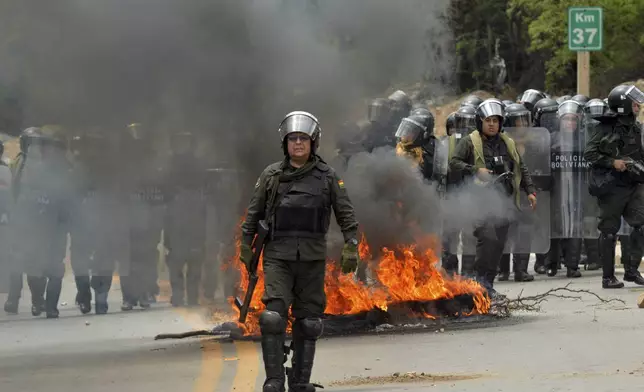 Riot police clash with supporters of former Bolivian President Evo Morales during a roadblock to pressure against him being prosecuted over allegations of minor abuse, near Cochabamba, Bolivia, Friday, Oct. 25, 2024. (AP Photo/Daniel Cartagena)