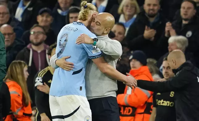 Manchester City's Erling Haaland celebrates with head coach Pep Guardiola after scoring his side's fourth goal during the Champions League opening phase soccer match between Manchester City and Sparta Praha at the Etihad Stadium in Manchester, England, Wednesday, Oct.23 , 2024. (AP Photo/Dave Thompson)
