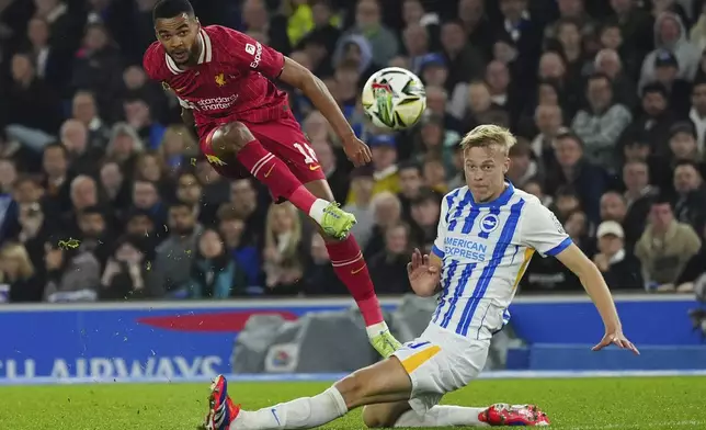 Liverpool's Cody Gakpo, left, shoots for a goal by Brighton's Jan Paul van Hecke during the English League Cup soccer match between Brighton and Liverpool at Falmer Stadium in Brighton, England, Wednesday, Oct. 30, 2024. (AP Photo/Dave Shopland)