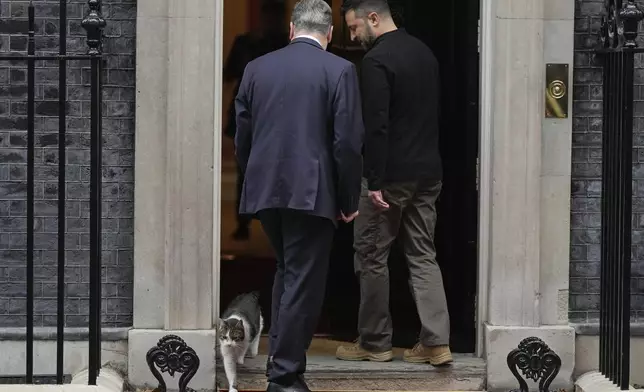 Britain's Prime Minister Keir Starmer welcomes Ukrainian President Volodymyr Zelenskyy to 10 Downing Street as Larry the cat, Chief Mouser to the Cabinet Office, steps out in London, Thursday, Oct. 10, 2024.(AP Photo/Alastair Grant)