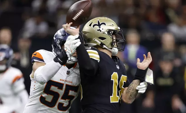 New Orleans Saints quarterback Spencer Rattler (18) fumbles the ball as he is hit by Denver Broncos linebacker Cody Barton (55) during the first half of an NFL football game, Thursday, Oct. 17, 2024, in New Orleans. The Broncos recovered the fumble. (AP Photo/Butch Dill)