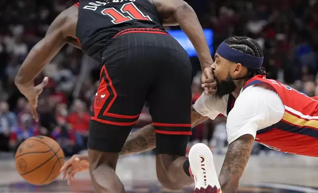 New Orleans Pelicans forward Brandon Ingram dives for a loose ball against Chicago Bulls guard Ayo Dosunmu (11) in the first half of an NBA basketball game in New Orleans, Wednesday, Oct. 23, 2024. (AP Photo/Gerald Herbert)