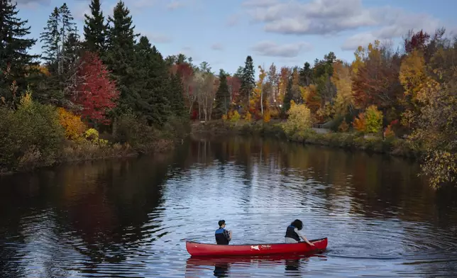 Canoeists paddle in Centennial Park as the foliage continues to change color in Moncton, New Brunswick, Canada, Tuesday, Oct. 22, 2024. (Darren Calabrese/The Canadian Press via AP)