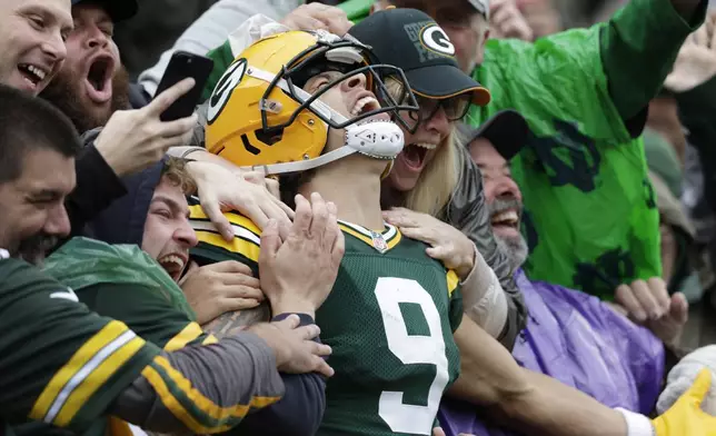 Green Bay Packers wide receiver Christian Watson celebrates his 44-yard reception for a touchdown with fans during the first half of an NFL football game against the Arizona Cardinals, Sunday, Oct. 13, 2024, in Green Bay. (AP Photo/Matt Ludtke)