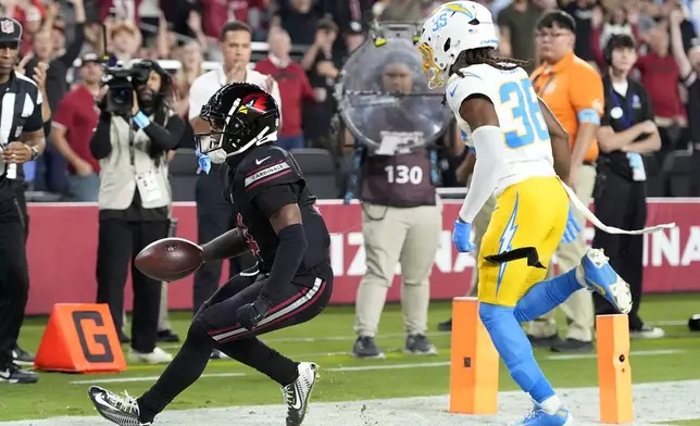 Arizona Cardinals wide receiver Greg Dortch catches a 5-yard touchdown pass in front of Los Angeles Chargers cornerback Ja'Sir Taylor (36) during the first half of an NFL football game, Monday, Oct. 21, 2024, in Glendale Ariz. (AP Photo/Ross D. Franklin)