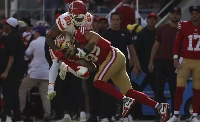 San Francisco 49ers tight end George Kittle, bottom, catches a pass against Kansas City Chiefs safety Justin Reid during the first half of an NFL football game in Santa Clara, Calif., Sunday, Oct. 20, 2024. (AP Photo/Jed Jacobsohn)