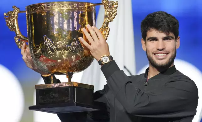 Carlos Alcaraz of Spain poses with his trophy after winning against Jannik Sinner of Italy during their men's singles finals match of the China Open tennis tournament, at the National Tennis Center in Beijing, Wednesday, Oct. 2, 2024. (AP Photo/Achmad Ibrahim)