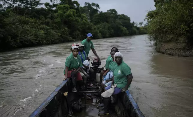 A group of women, part of Asociacion Nuestra Casa Comun, or Our Community House Association, go by boat to an area destroyed by illegal mining, on the Quito River, near Paimado, Colombia, Tuesday, Sept. 24, 2024. (AP Photo/Ivan Valencia)