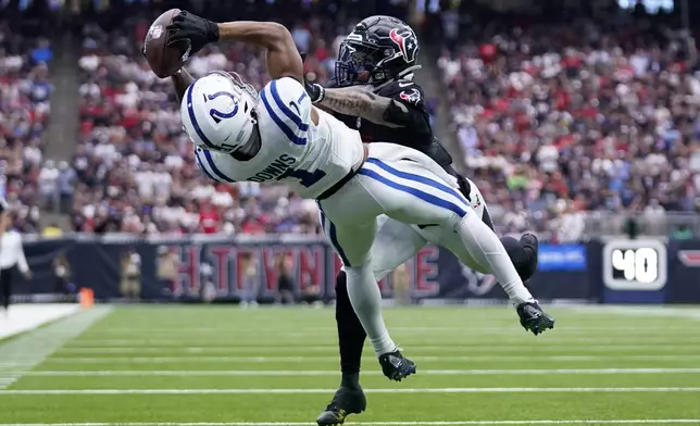 Indianapolis Colts wide receiver Josh Downs (1) catches a pass over Houston Texans safety Jalen Pitre during the second half of an NFL football game, Sunday, Oct. 27, 2024, in Houston. (AP Photo/Eric Christian Smith)