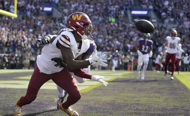 Washington Commanders wide receiver Terry McLaurin, front, catches a 6-yard touchdown pass as Baltimore Ravens defensive back Brandon Stephens, rear, defends during the second half of an NFL football game Sunday, Oct. 13, 2024, in Baltimore. (AP Photo/Stephanie Scarbrough)