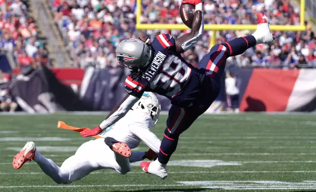 New England Patriots running back Rhamondre Stevenson (38) hangs onto the ball after colliding with Miami Dolphins cornerback Kader Kohou (4) during the first half of an NFL football game, Sunday, Oct. 6, 2024, in Foxborough, Mass. (AP Photo/Steven Senne)