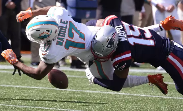 New England Patriots safety Marte Mapu (15) tackles Miami Dolphins wide receiver Jaylen Waddle (17), who drops a pass, during the first half of an NFL football game, Sunday, Oct. 6, 2024, in Foxborough, Mass. (AP Photo/Michael Dwyer)