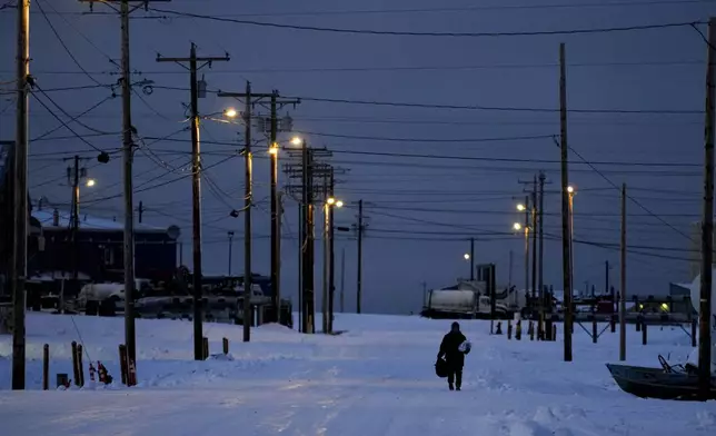 A villager walks through the snow in Kaktovik, Alaska, Monday, Oct. 14, 2024. (AP Photo/Lindsey Wasson)