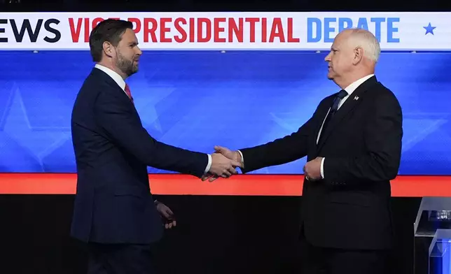 Republican vice presidential nominee Sen. JD Vance, R-Ohio, left, and Democratic vice presidential nominee Minnesota Gov. Tim Walz, shake hands as they arrive for a CBS News vice presidential debate, Tuesday, Oct. 1, 2024, in New York. (AP Photo/Julia Demaree Nikhinson)