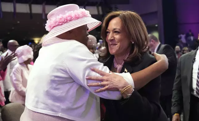 Democratic presidential nominee Vice President Kamala Harris, right, hugs an attendee at a church service before speaking at New Birth Baptist Church in Stonecrest, Ga., Sunday, Oct. 20, 2024. (AP Photo/Jacquelyn Martin)