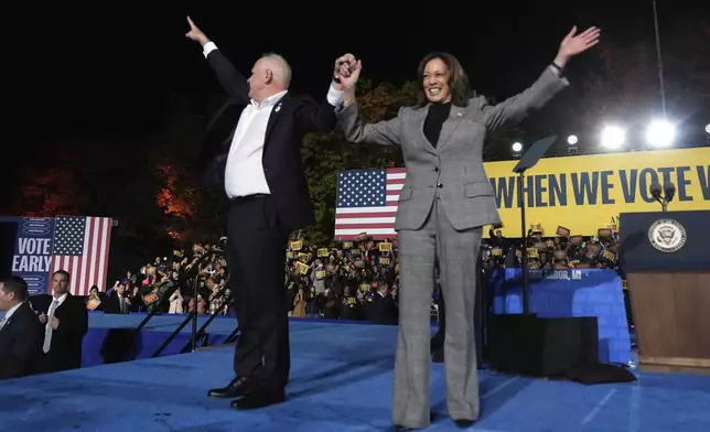 Democratic presidential nominee Vice President Kamala Harris, right, and her running mate Minnesota Gov. Tim Walz depart after speaking during a campaign rally at Burns Park in Ann Arbor, Mich., Monday, Oct. 28, 2024. (AP Photo/Paul Sancya)