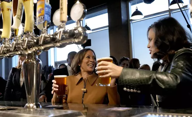 Democratic presidential nominee Vice President Kamala Harris, left, and Michigan Gov. Gretchen Whitmer hold beers while speaking at the Trak Houz Bar &amp; Grill after a campaign rally in Kalamazoo, Mich. (AP Photo/Jacquelyn Martin)