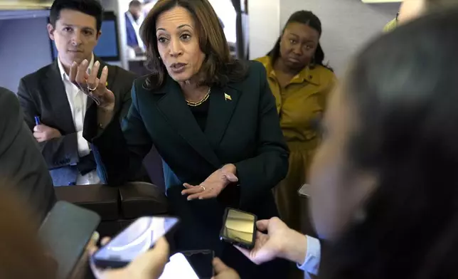 Democratic presidential nominee Vice President Kamala Harris speaks with members of the press on board Air Force Two at Philadelphia International Airport, Monday, Oct. 21, 2024, in Philadelphia, before departing to Michigan. (AP Photo/Jacquelyn Martin, Pool)