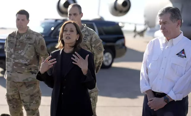 Democratic presidential nominee Vice President Kamala Harris speaks alongside North Carolina Gov. Roy Cooper, right, near a C-17 cargo plane after receiving a briefing on the damage from Hurricane Helene, Saturday, October 5, 2024, at the 145th Airlift Wing of the North Carolina Air National Guard in Charlotte, N.C. (AP Photo/Chris Carlson)