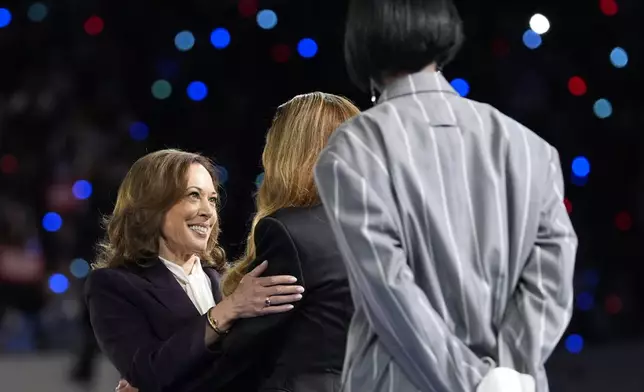 Democratic presidential nominee Vice President Kamala Harris, left, greeting musical artists Beyonce, center, and Kelly Rowland, right, on stage at a campaign event in Houston, Friday, Oct. 25, 2024. (AP Photo/Susan Walsh)