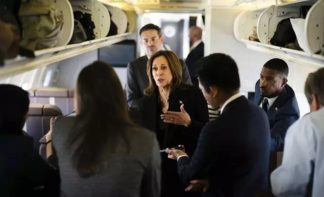 Democratic presidential candidate Vice President Kamala Harris talks to reporters aboard Air Force Two at Joint Base Andrews, Md., Wednesday, Oct. 23, 2024. (Erin Schaff//The New York Times via AP, Pool)