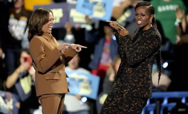 Democratic presidential nominee Vice President Kamala Harris, left, and former first lady Michelle Obama arrive to speak at a campaign rally at the Wings Event Center, Saturday, Oct. 26, 2024, in Kalamazoo, Mich. (AP Photo/Paul Sancya)