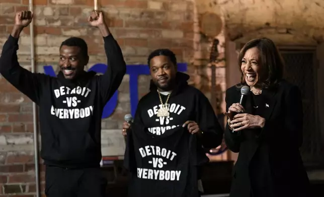 Democratic presidential nominee Vice President Kamala Harris speaks as Detroit vs Everybody co-founders Sean Xavier Williams, left, and Tommey Walker, listen, during a stop at Cred Cafe, a local Detroit small business owned by former NBA players Joe and Jamal Crawford, in Detroit, Tuesday, Oct. 15, 2024. (AP Photo/Jacquelyn Martin)