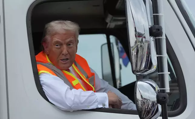 Republican presidential nominee former President Donald Trump talks to reporters as he sits in a garbage truck Wednesday, Oct. 30, 2024, in Green Bay, Wis. (AP Photo/Julia Demaree Nikhinson)