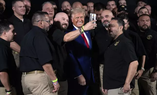 Republican presidential nominee former President Donald Trump talks with members of the U.S. Border Patrol before speaking at a campaign rally, Sunday, Oct. 13, 2024, in Prescott Valley, Ariz. (AP Photo/Evan Vucci)