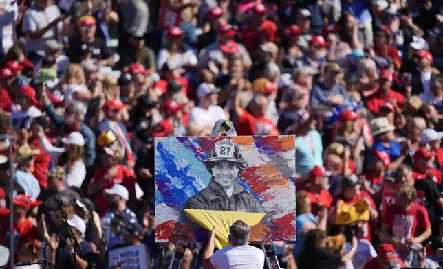 Artist Scott LaBaido unveils a painting of Corey Comperatore before Republican presidential nominee former President Donald Trump speaks at a campaign rally at the Butler Farm Show, Saturday, Oct. 5, 2024, in Butler, Pa. (AP Photo/Julia Demaree Nikhinson)