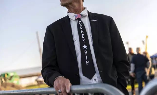 A supporter of Republican presidential nominee former President Donald Trump wears a tie honoring firefighter Corey Comperatore while waiting to enter a campaign rally at the Butler Farm Show, Saturday, Oct. 5, 2024, in Butler, Pa. (AP Photo/Julia Demaree Nikhinson)