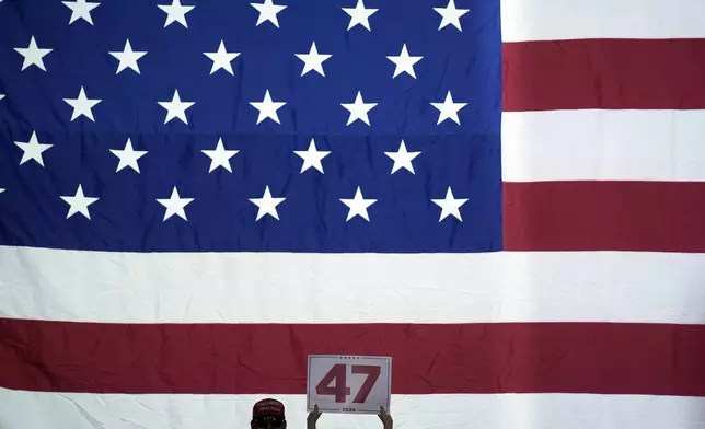 A supporter holds a sign as Republican presidential nominee former President Donald Trump speaks at a town hall at Lancaster County Convention Center, Sunday, Oct. 20, 2024, in Lancaster, Pa. (AP Photo/Evan Vucci)