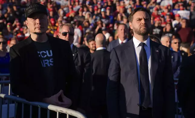 Elon Musk and Republican vice presidential nominee Sen. JD Vance, R-Ohio, listen as Republican presidential nominee former President Donald Trump speaks at a campaign rally at the Butler Farm Show, Saturday, Oct. 5, 2024, in Butler, Pa. (AP Photo/Evan Vucci)