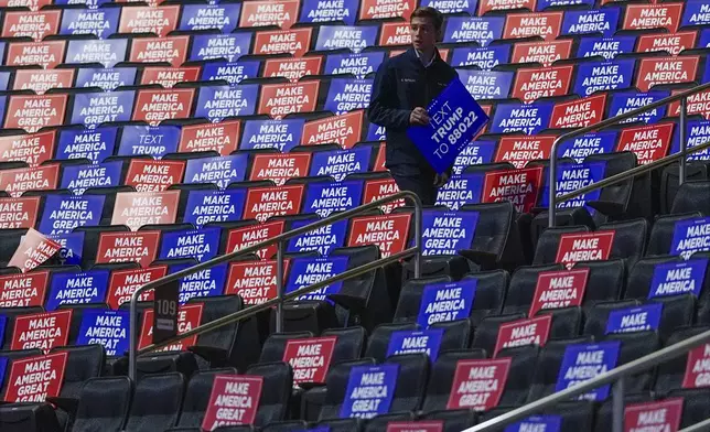 A worker places signs in seats before Republican presidential nominee former President Donald Trump speaks at a campaign rally at Madison Square Garden, Sunday, Oct. 27, 2024, in New York. (AP Photo/Julia Demaree Nikhinson)