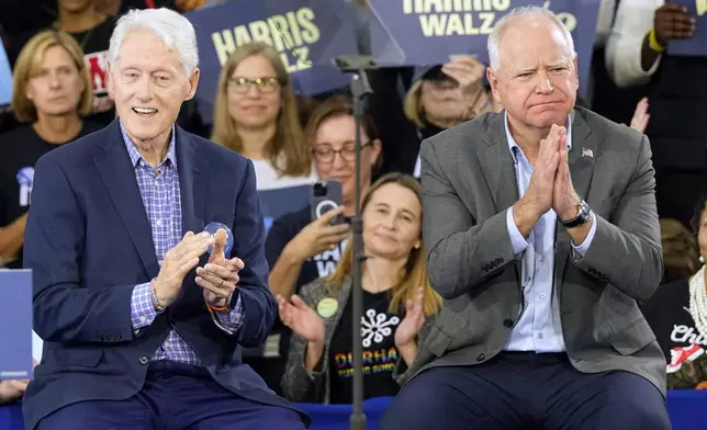 Democratic vice presidential nominee Minnesota Gov. Tim Walz, appears with former President Bill Clinton at a campaign rally in Durham, N.C., Thursday, Oct. 17, 2024. (AP Photo/Steve Helber)