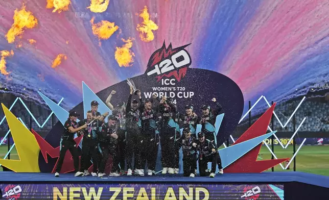 New Zealand's players pose with the trophy after winning the ICC Women's T20 World Cup 2024 final match against South Africa at Dubai International Cricket Stadium, United Arab Emirates, Sunday, Oct. 20, 2024. (AP Photo/Altaf Qadri)