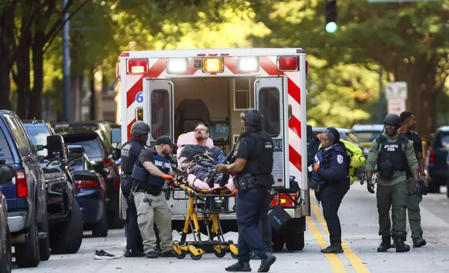 After an hours-long standoff, a suspect is taken into custody with visible injuries on 14th Street outside the Four Seasons Hotel after gunshots were reported in the Midtown neighborhood of Atlanta, Tuesday, Oct. 29, 2024. (Miguel Martinez/Atlanta Journal-Constitution via AP)