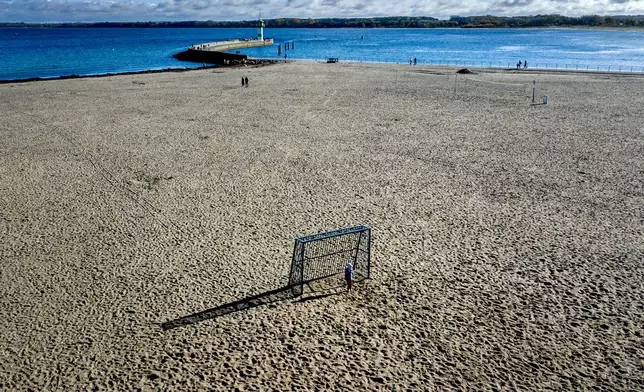 A small boy keeps goal on the beach of the Baltic Sea in Travemuende, Germany, Tuesday, Oct. 22, 2024. (AP Photo/Michael Probst)