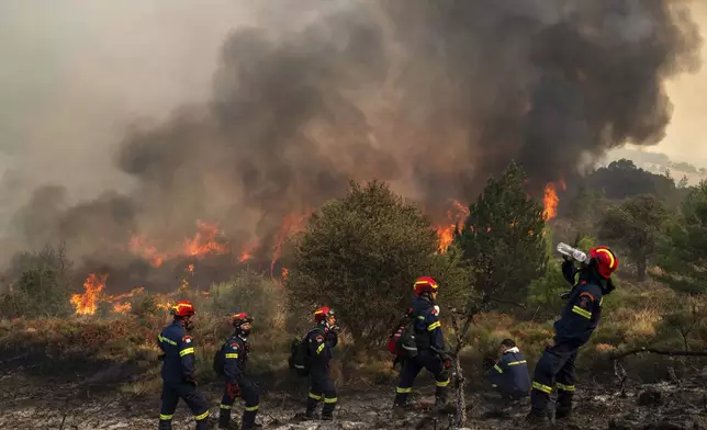 A firefighter drinks water during a third day of a wildfire in Sofiana village, about 142 kilometers (88 miles) west of Athens, Greece, on Tuesday, Oct. 1, 2024. (AP Photo/Petros Giannakouris)