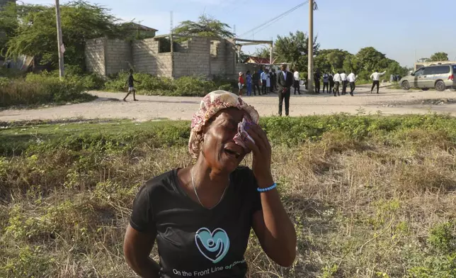 A neighbor cries during the funeral of Jean Louis Jeune Gracien, who was killed during an attack by armed gangs, in Pont-Sonde, Haiti, Tuesday, Oct. 8, 2024. (AP Photo/Odelyn Joseph)