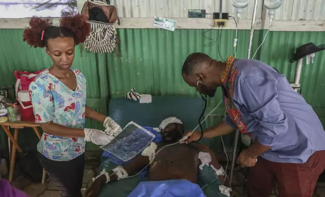 Doctors treat a man who was shot and wounded during armed gang attacks, at Saint Nicolas hospital in Saint-Marc, Haiti, Sunday, Oct. 6, 2024. (AP Photo/Odelyn Joseph)