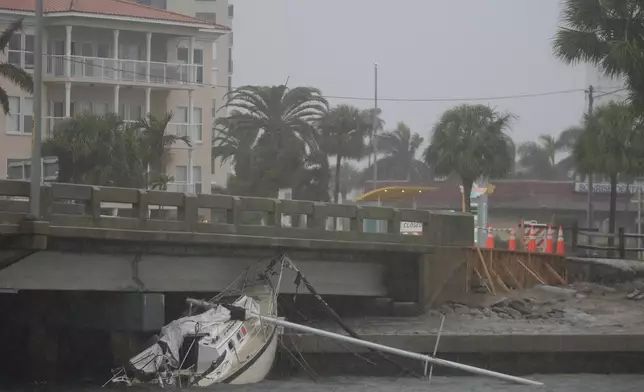 A boat damaged in Hurricane Helene rests against a bridge ahead of the arrival of Hurricane Milton, in South Pasadena, Fla., Wednesday, Oct. 9, 2024. (AP Photo/Rebecca Blackwell)