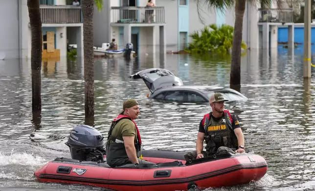 A water rescue boat moves in flood waters at an apartment complex in the aftermath of Hurricane Milton, Thursday, Oct. 10, 2024, in Clearwater, Fla. (AP Photo/Mike Stewart)