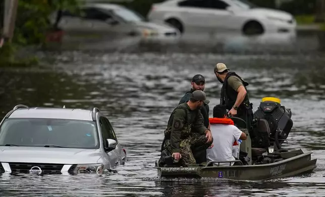 People are rescued from an apartment complex in the aftermath of Hurricane Milton, Thursday, Oct. 10, 2024, in Clearwater, Fla. (AP Photo/Mike Stewart)