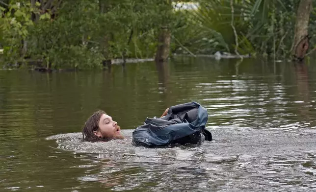 Connor Hughes of Lithia, Fla., moves in deep floodwaters from Hurricane Milton along the Alafia river Friday, Oct. 11, 2024, in Lithia, Fla. (AP Photo/Chris O'Meara)