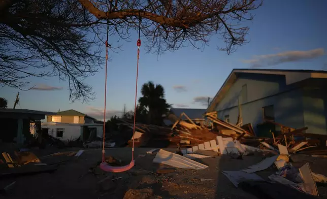 A child's swing still hangs on a tree, surrounded by debris from homes destroyed by Hurricane Milton, on Manasota Key, Fla., Saturday, Oct. 12, 2024. (AP Photo/Rebecca Blackwell)