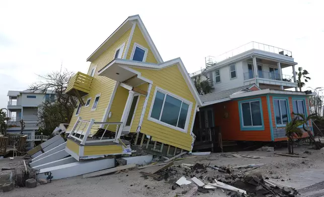 A house lies toppled off its stilts after the passage of Hurricane Milton, in Bradenton Beach on Anna Maria Island, Fla., Thursday, Oct. 10, 2024. (AP Photo/Rebecca Blackwell)