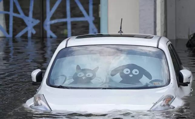 A car is submerged in flood water at an apartment complex in the aftermath of Hurricane Milton, Thursday, Oct. 10, 2024, in Clearwater, Fla. (AP Photo/Mike Stewart)