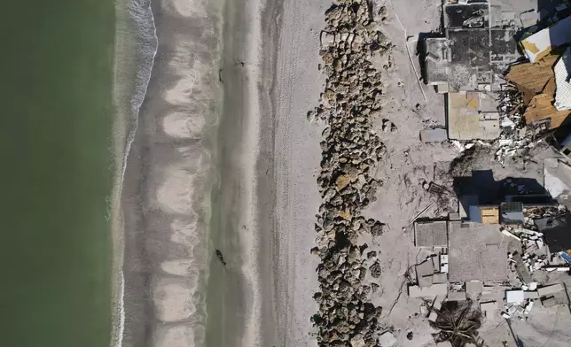 Waves lap on the beach in front of empty house foundations surrounded by debris, following the passage of Hurricane Milton, on Manasota Key, in Englewood, Fla., Sunday, Oct. 13, 2024. (AP Photo/Rebecca Blackwell)