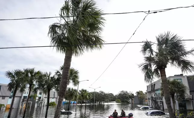 A water rescue boat moves in flood waters at an apartment complex in the aftermath of Hurricane Milton, Thursday, Oct. 10, 2024, in Clearwater, Fla. (AP Photo/Mike Stewart)